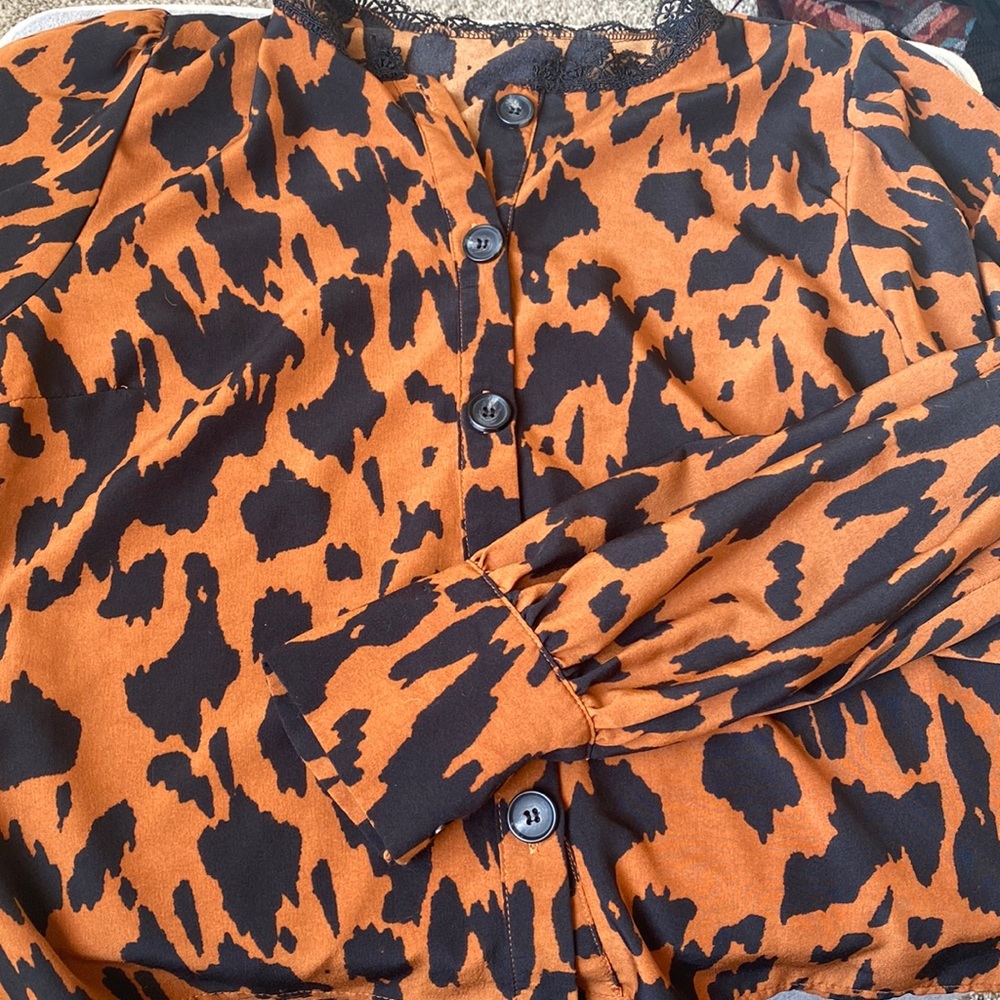 Super cute cheetah print blouse. Has beveled sleeves and a lace collar.
